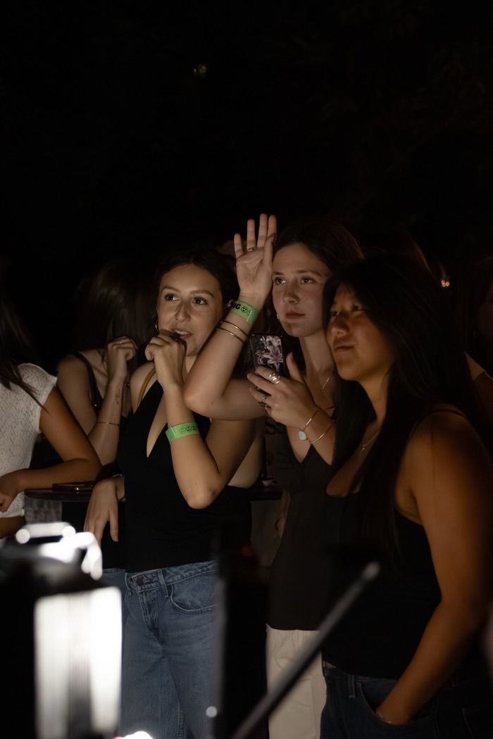 Audience members raising their hands to ask the contestants a question